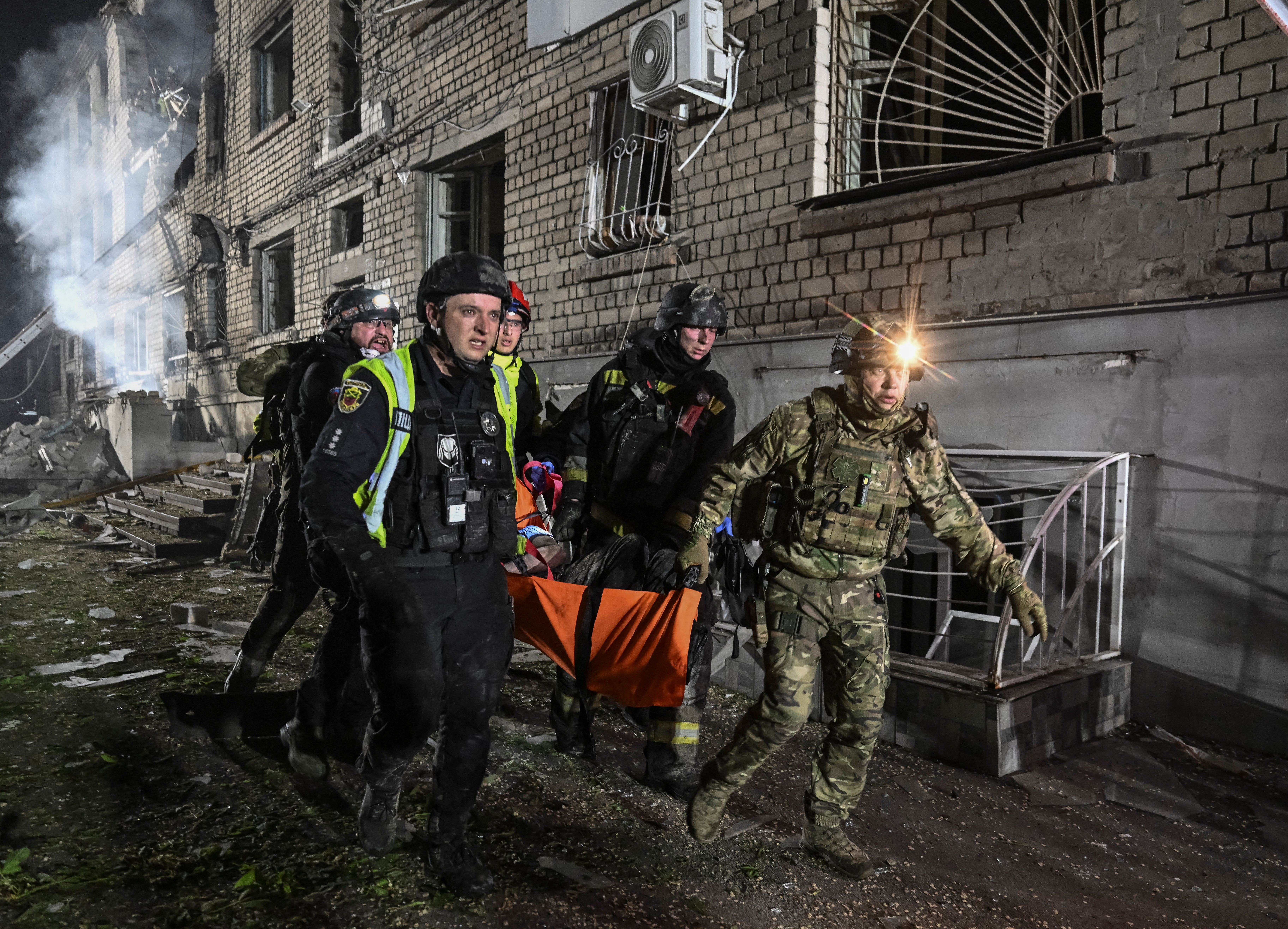 Rescuers evacuate a wounded resident from an apartment building damaged during a Russian drone strik