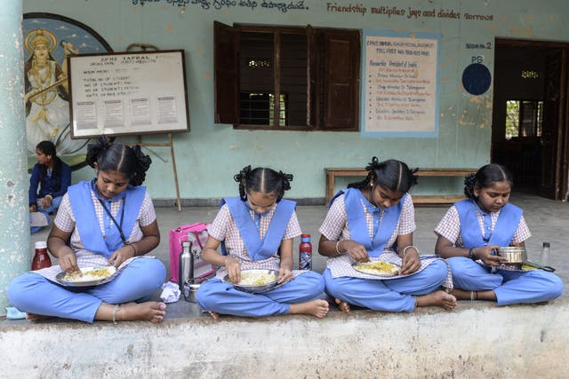 <p>File. Students eat their free midday meal at a school on the outskirts of Hyderabad, India, on 23 November 2021</p>