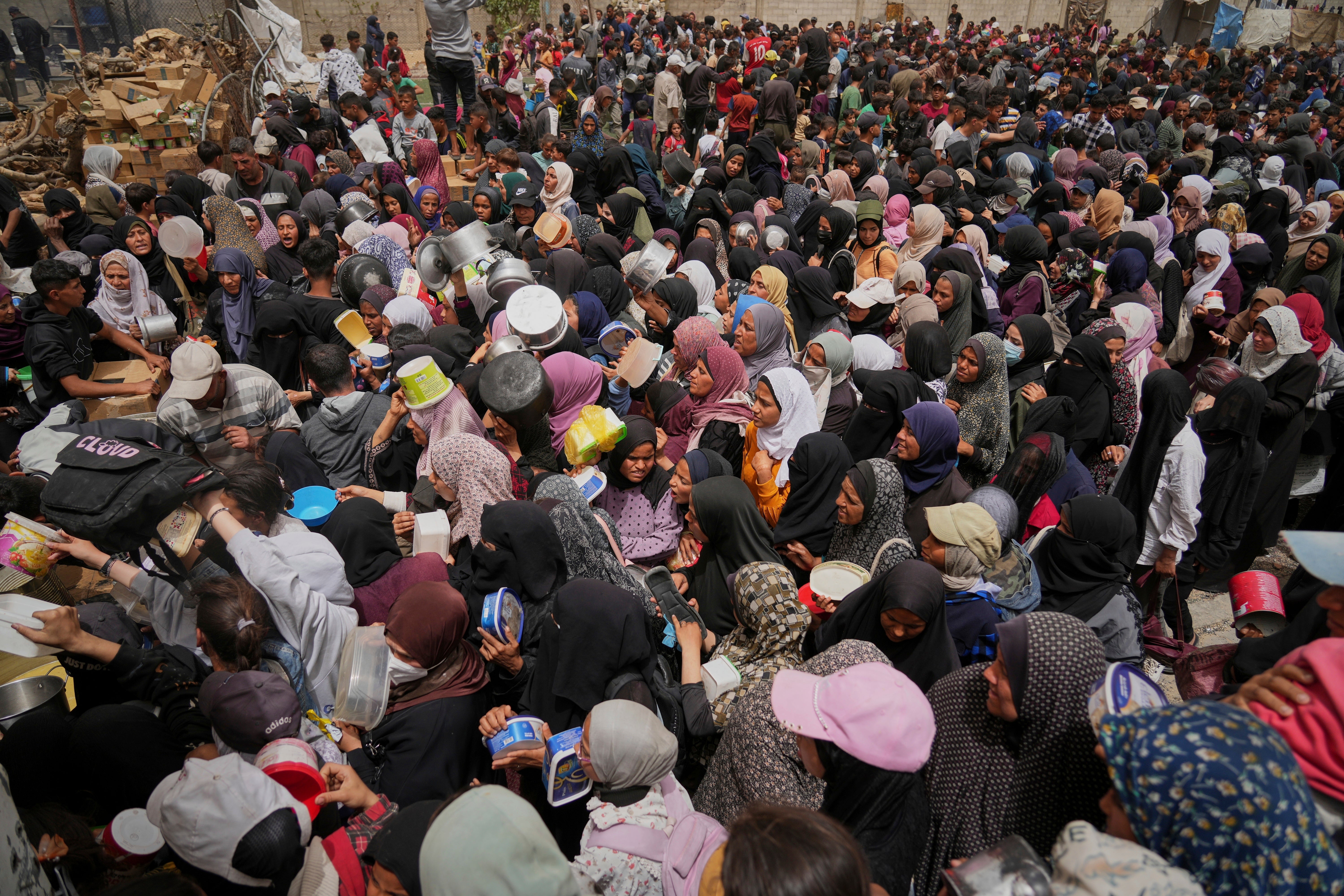 Palestinians struggle in a crowd as they try to receive donated food at a distribution center in Nuseirat, central Gaza Strip in April 2025