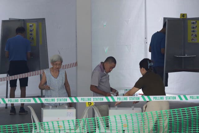 <p>Residents cast their vote at a polling station during the general election in Singapore on Saturday</p>