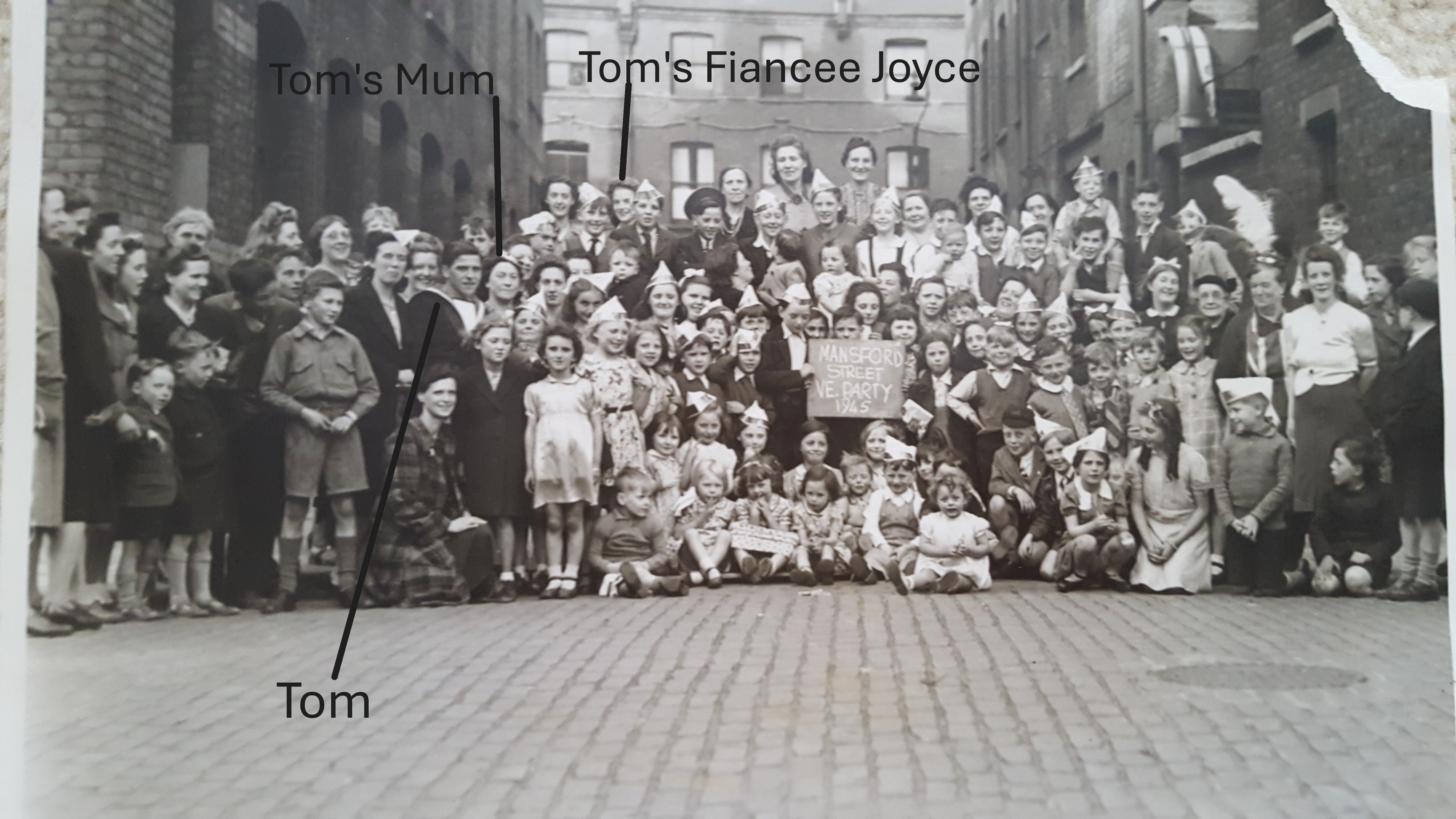 Veteran Thomas Cuthbert (in naval uniform, standing front, centre left), beside his mother at a VE tea party (Collect/Blind Veterans UK/PA)