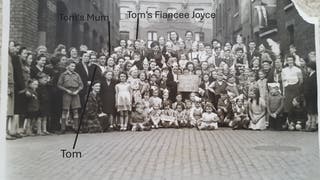 Veteran Thomas Cuthbert (in naval uniform, standing front, centre left), beside his mother at a VE tea party (Collect/Blind Veterans UK/PA)