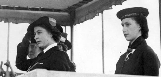 <p>Princess Elizabeth, in her uniform of Sea Ranger, and Princess Margaret (right), at Girl Guides march past the year in 1946 a year on from VE Day (PA)</p>