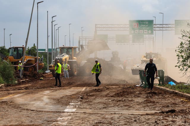 <p>Israeli emergency services clear a road outside Israel’s Ben Gurion airport after a missile launched from Yemen landed near the facility on 4 May 2025</p>