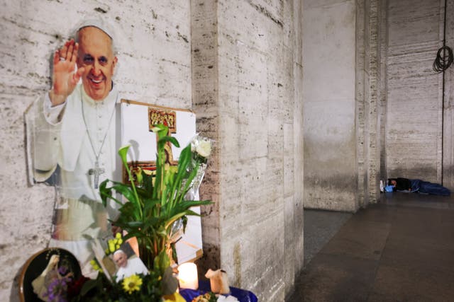 <p>A homeless person sleeps near to a makeshift memorial for Pope Francis near St Peter's Square, as seen from Rome, Italy April 24, 2025. REUTERS/Kai Pfaffenbach</p>
