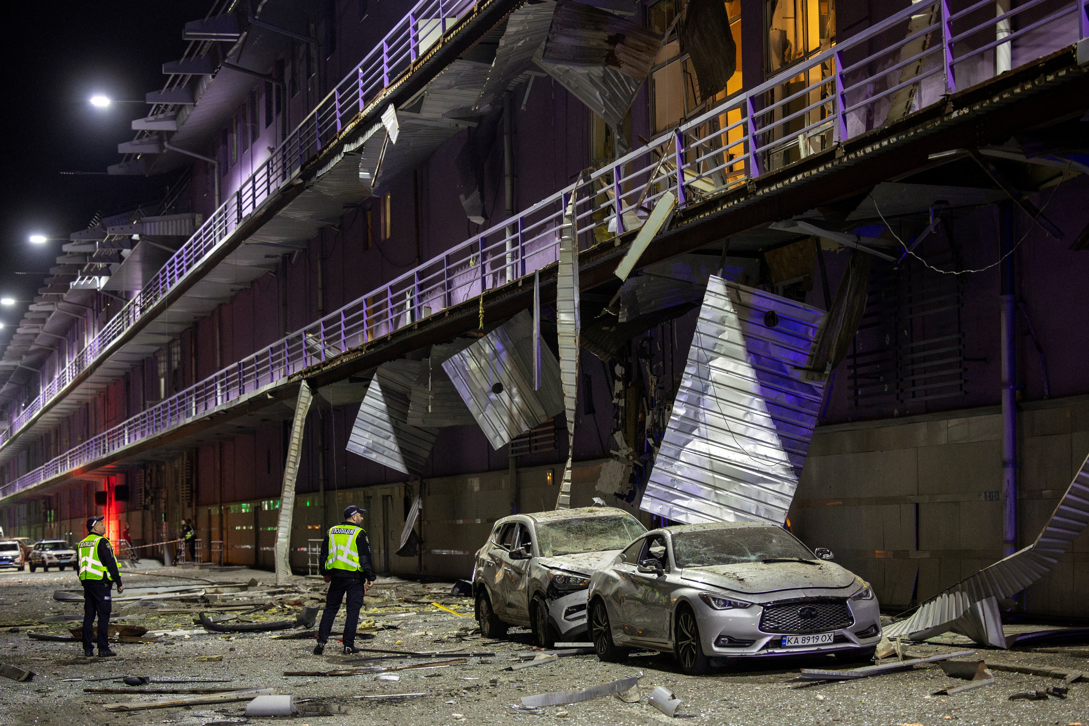 Policemen inspect a shopping mall that was damaged during a Russian drone attack in Kyiv on Sunday