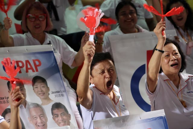 <p>Supporters of Singapore's prime minister and secretary general of the ruling People's Action Party (PAP), Lawrence Wong, react while watching on a screen the sample vote count during the preliminary results of the general elections on Saturday</p>