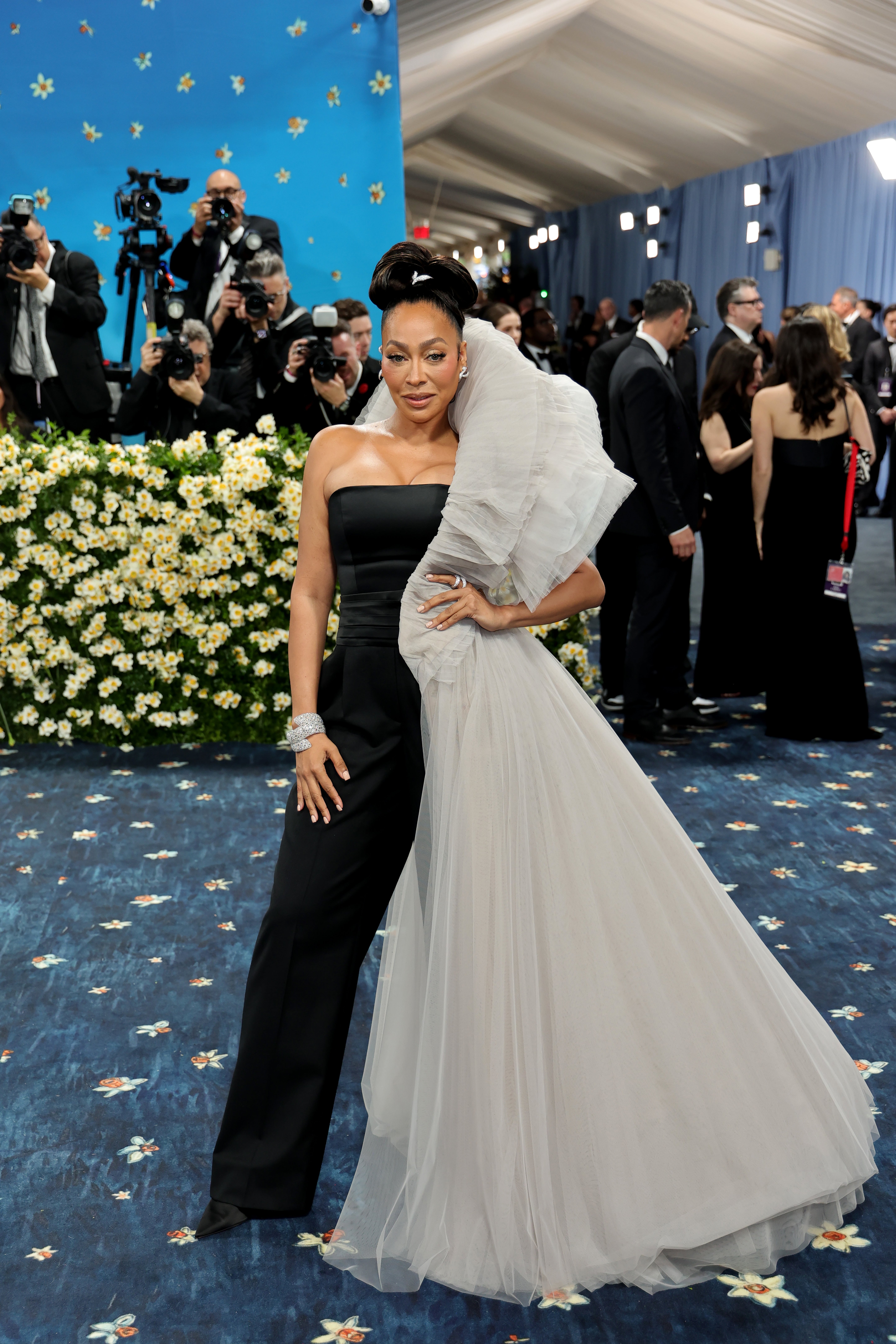 La La Anthony, Vogue’s red carpet livestream host, showed up to the 2025 Met Gala in a black satin jumpsuit embellished with a billowing, one-shoulder tulle sleeve and skirt