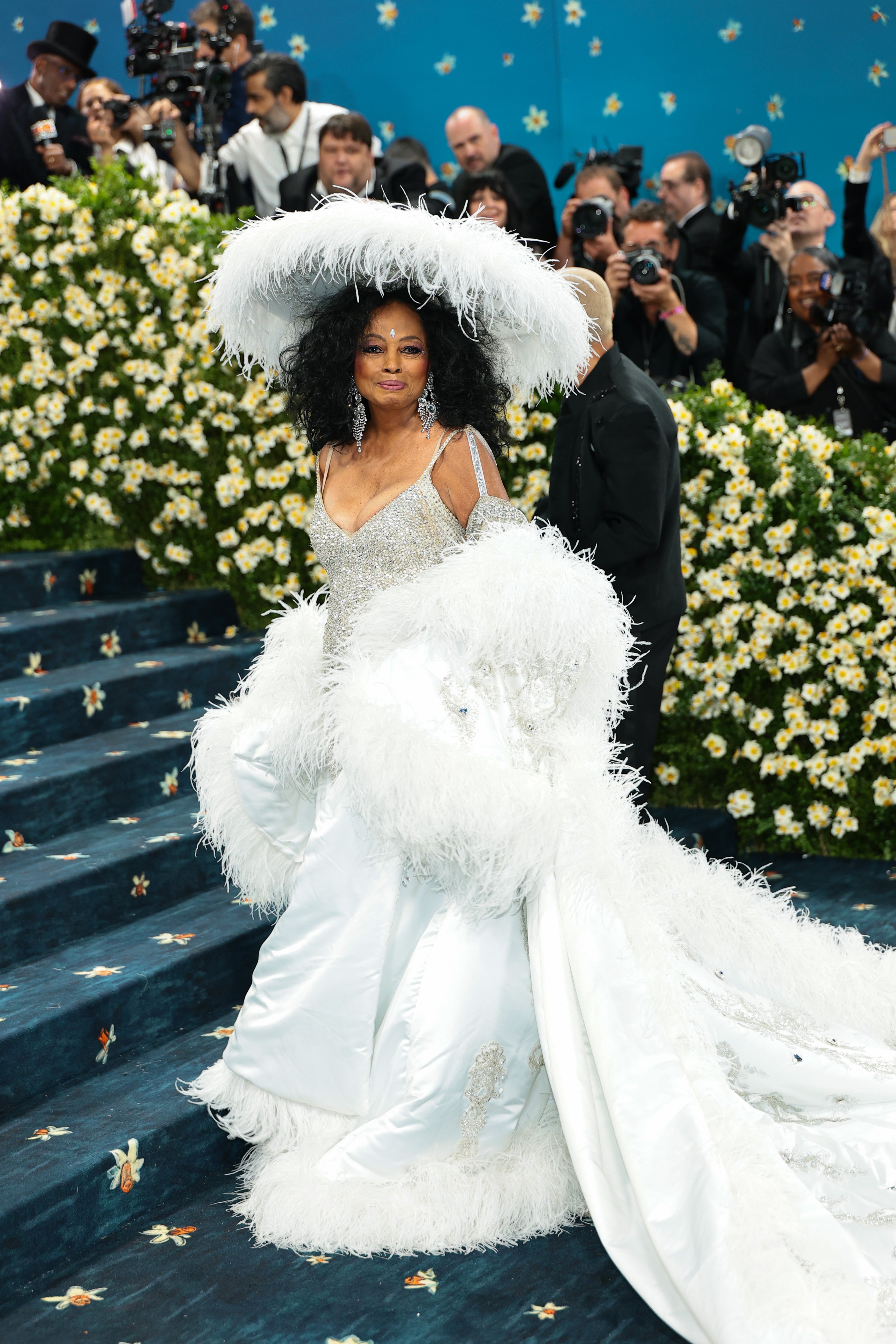 Diana Ross stunned in a silver dress with a satin white feather, skirt, paired with a matching feather train and skirt.