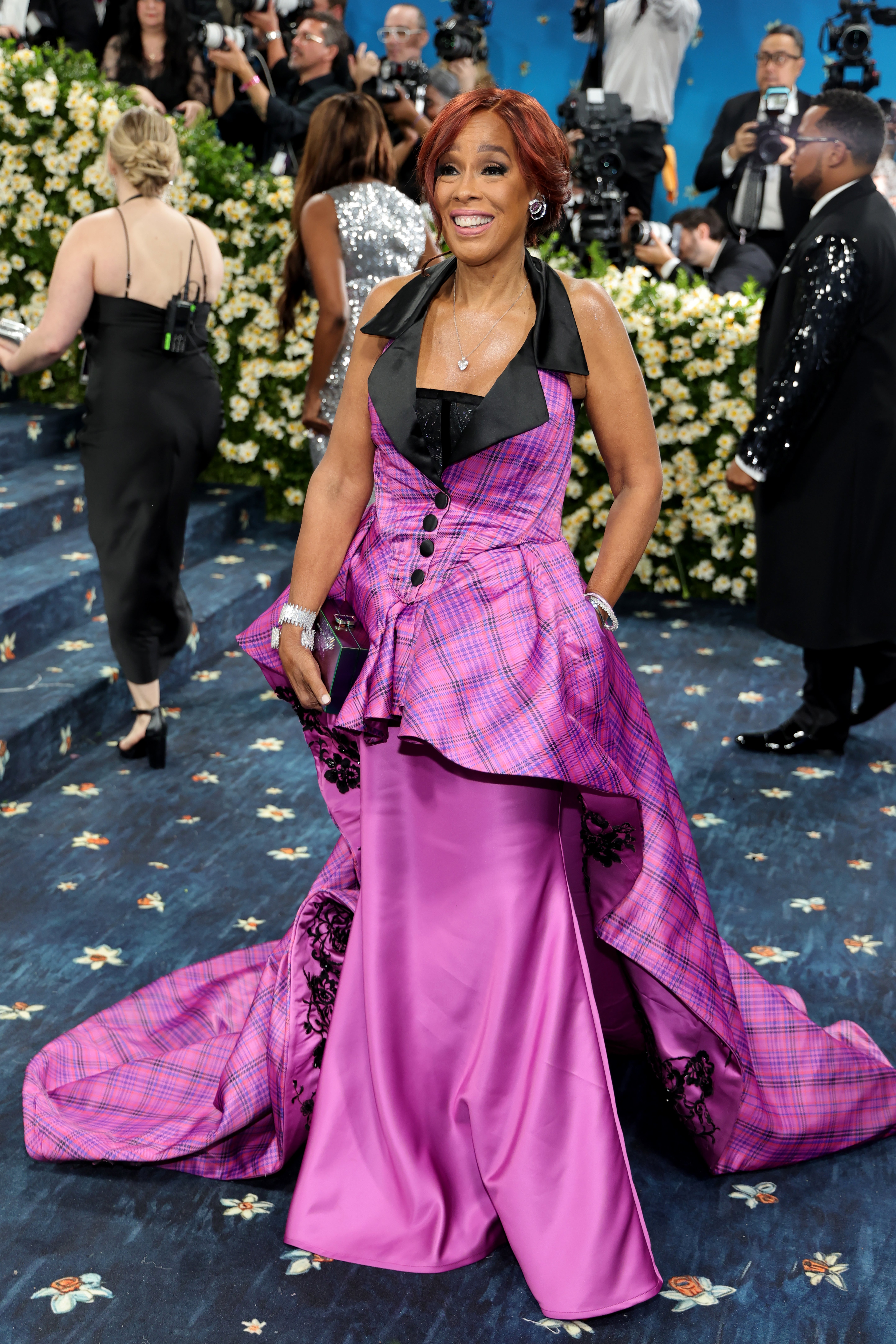 Gayle King posed in front of the cameras on the Met steps in a pink plaid dress with a long train stitched over a slim skirt