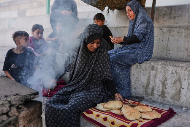 <p>Displaced Palestinians prepare bread in a makeshift oven in Gaza city</p>