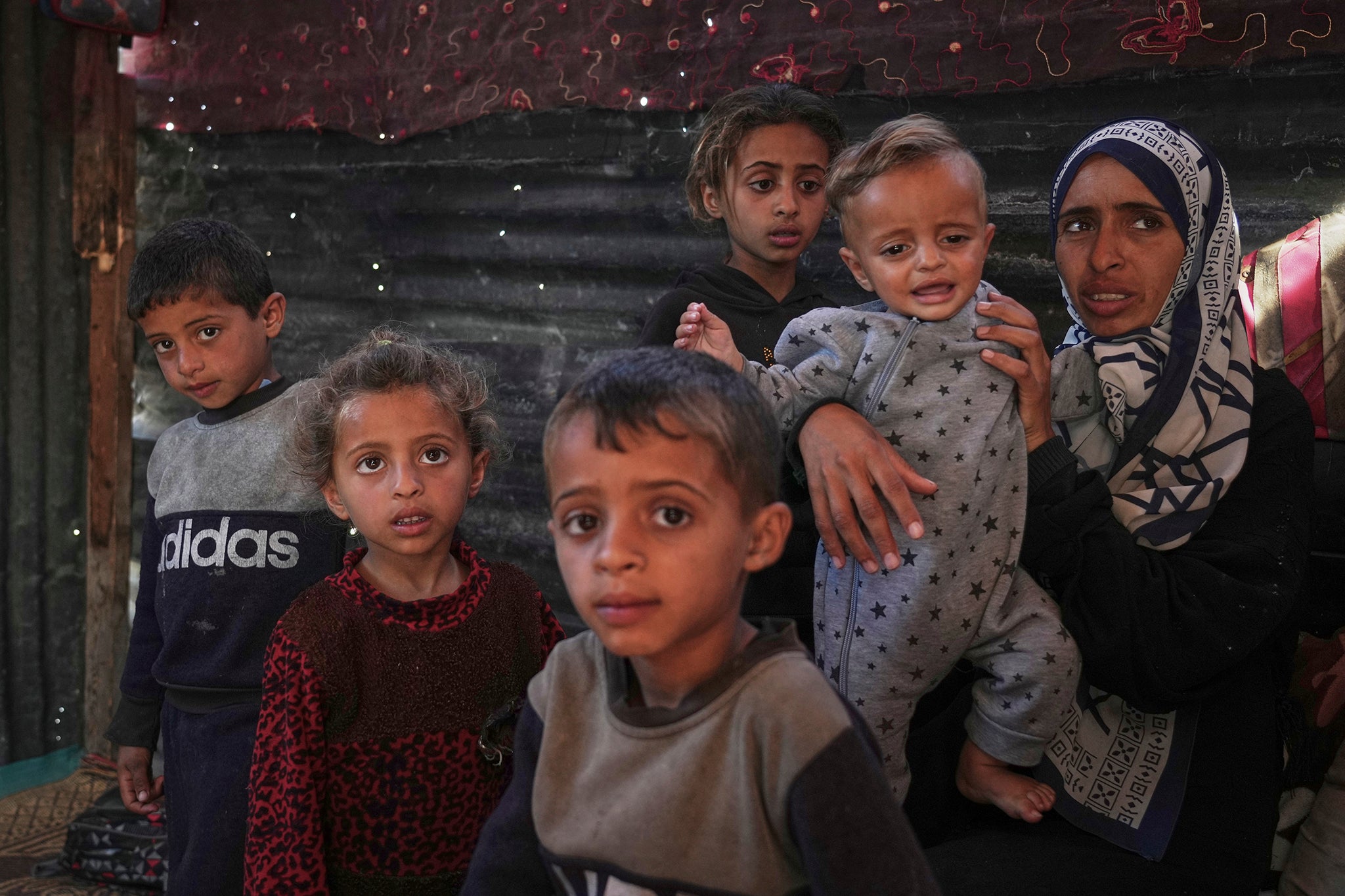 Wedad Abdelaal, right, and her 9-month-old son Khaled who is suffers from malnutrition and her children Ahmed, 7 and Maria, 4, (front) both showing signs of malnutrition at a camp in Mawasi, Khan Younis on May 2