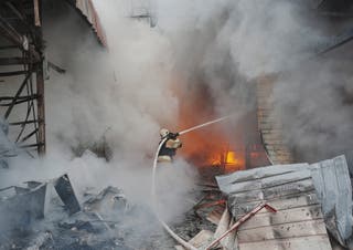 A firefighter works at the site of the Barabashovo market damaged heavily due to a Russian drone attack
