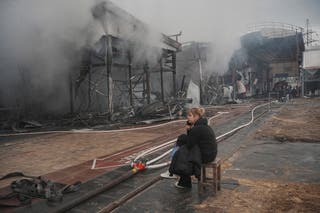 A vendor sits at the site of the Barabashovo market hit by Russian drone strike