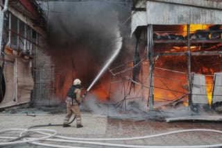A firefighter tries to bring the blaze at the Ukrainian market under control