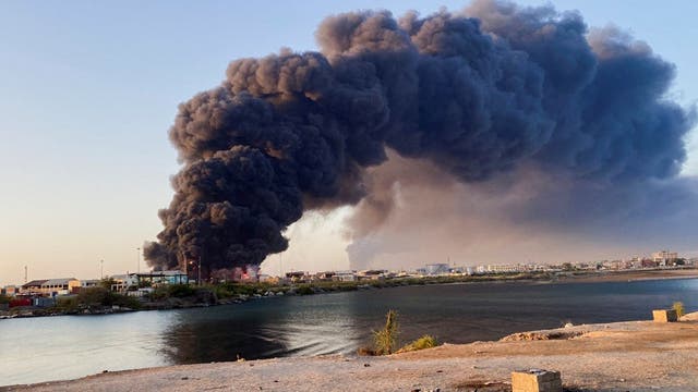 <p>A view shows a large plume of smoke and fire rising from fuel depot in Port Sudan</p>