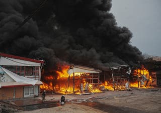 Firefighters work at the site of the Barabashovo market hit by Russian drone strike in Kharkiv