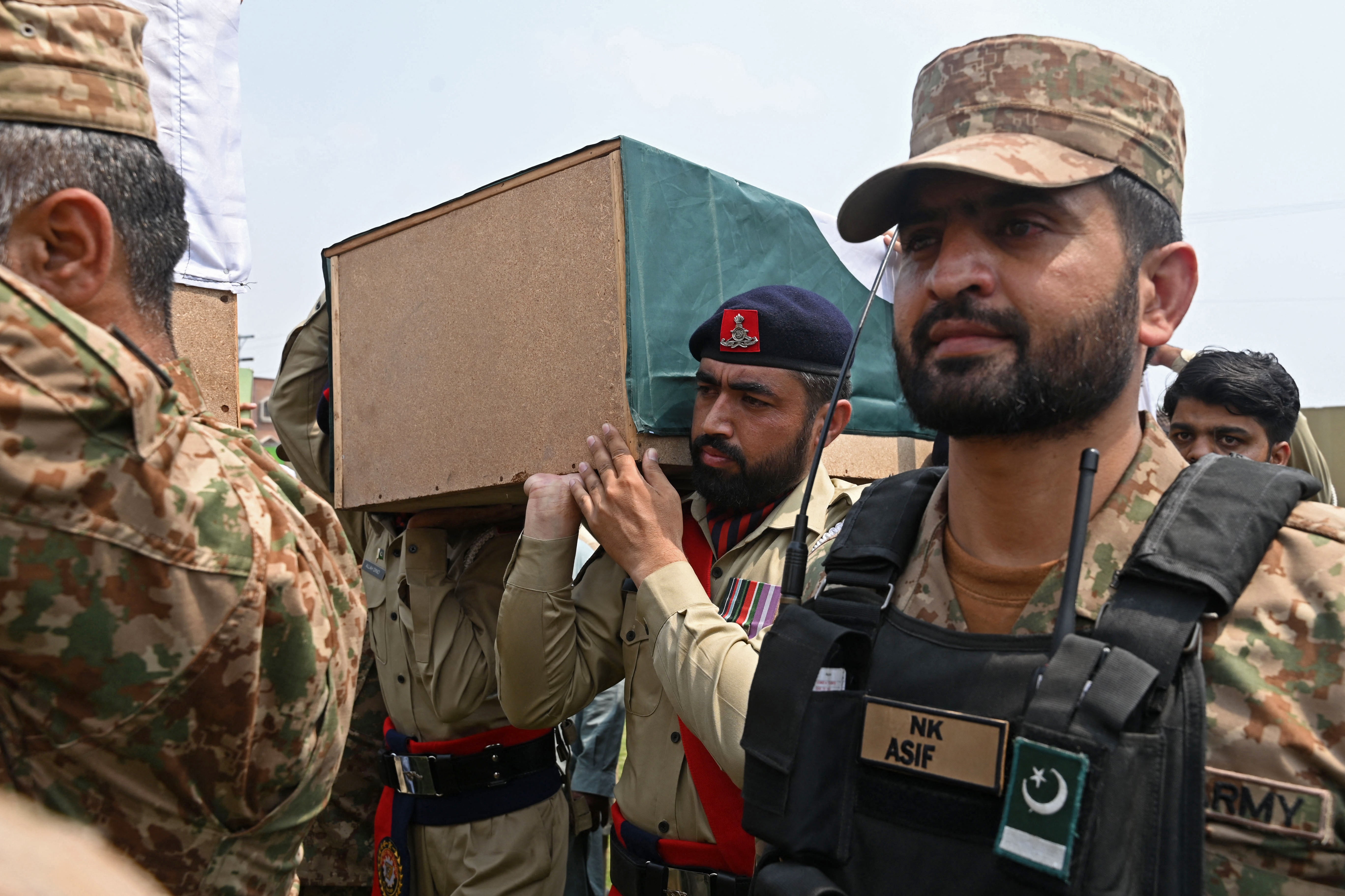 Security personnel carry the coffins of Indian strike victims during their funeral in Muridke, about 30 kms from Lahore, on Wednesday