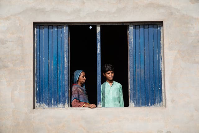 <p>Zain, a 13-year-old boy from rural Pakistan, whose life is already impacted by 50°C heatwaves, and whose home was destroyed by devastating floods in 2022. He is pictured with his mum, Sughra, 35</p>