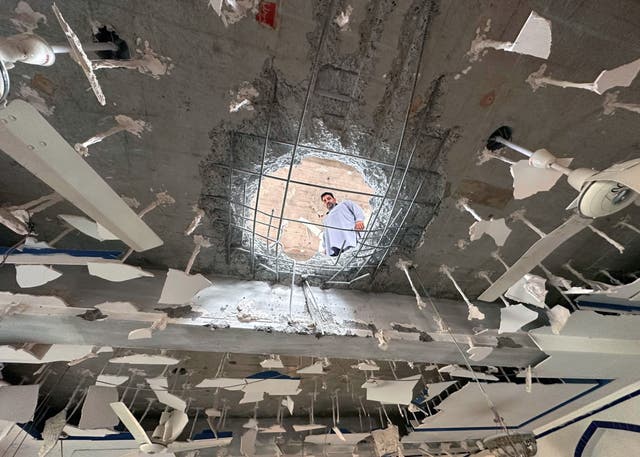 <p>A man looks on inside a damaged building after Indian missile strikes in Kotli, Pakistan-administered Kashmir</p>