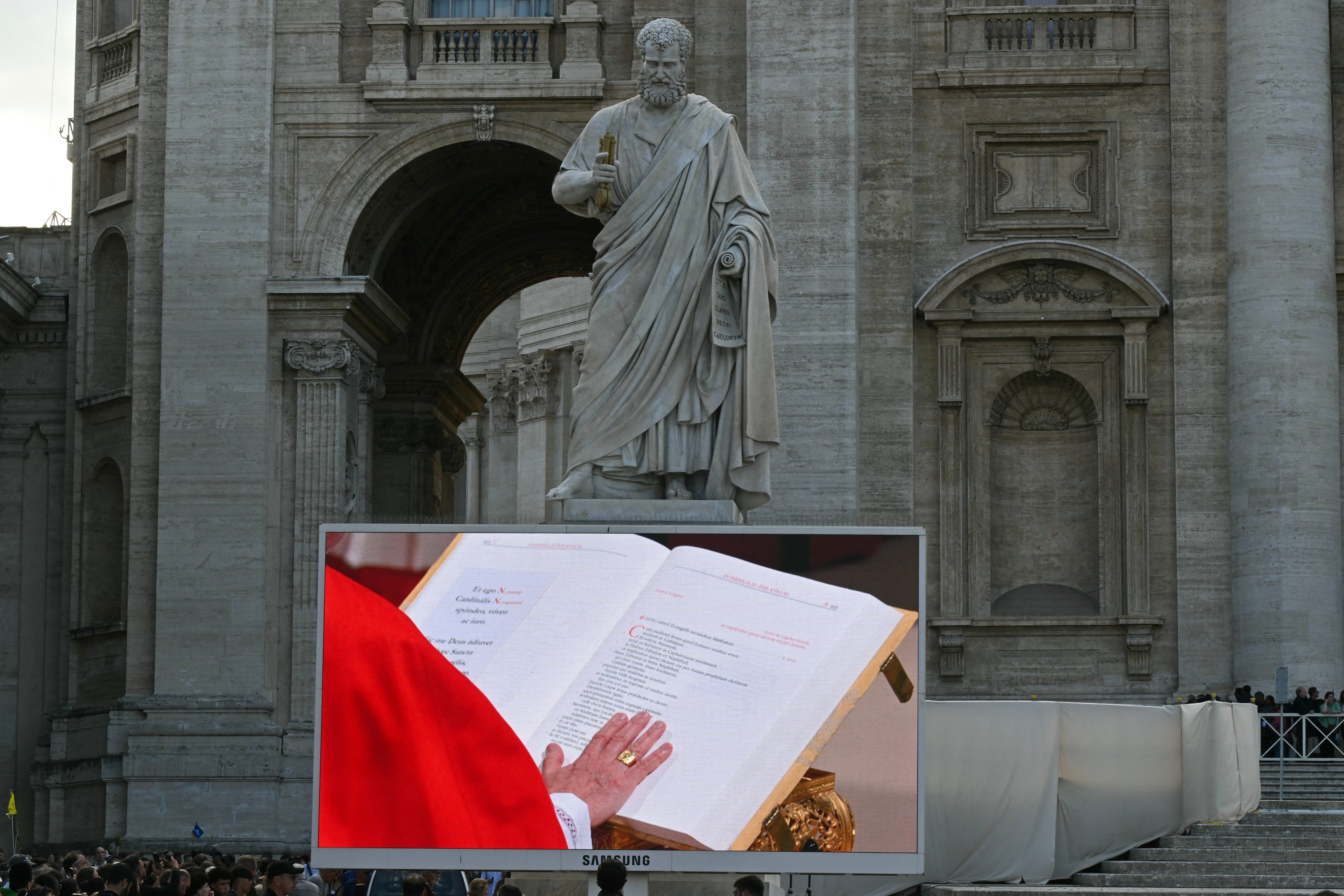 Faithful watch a giant screen displaying the holy mass of cardinals to the Sistine chapel