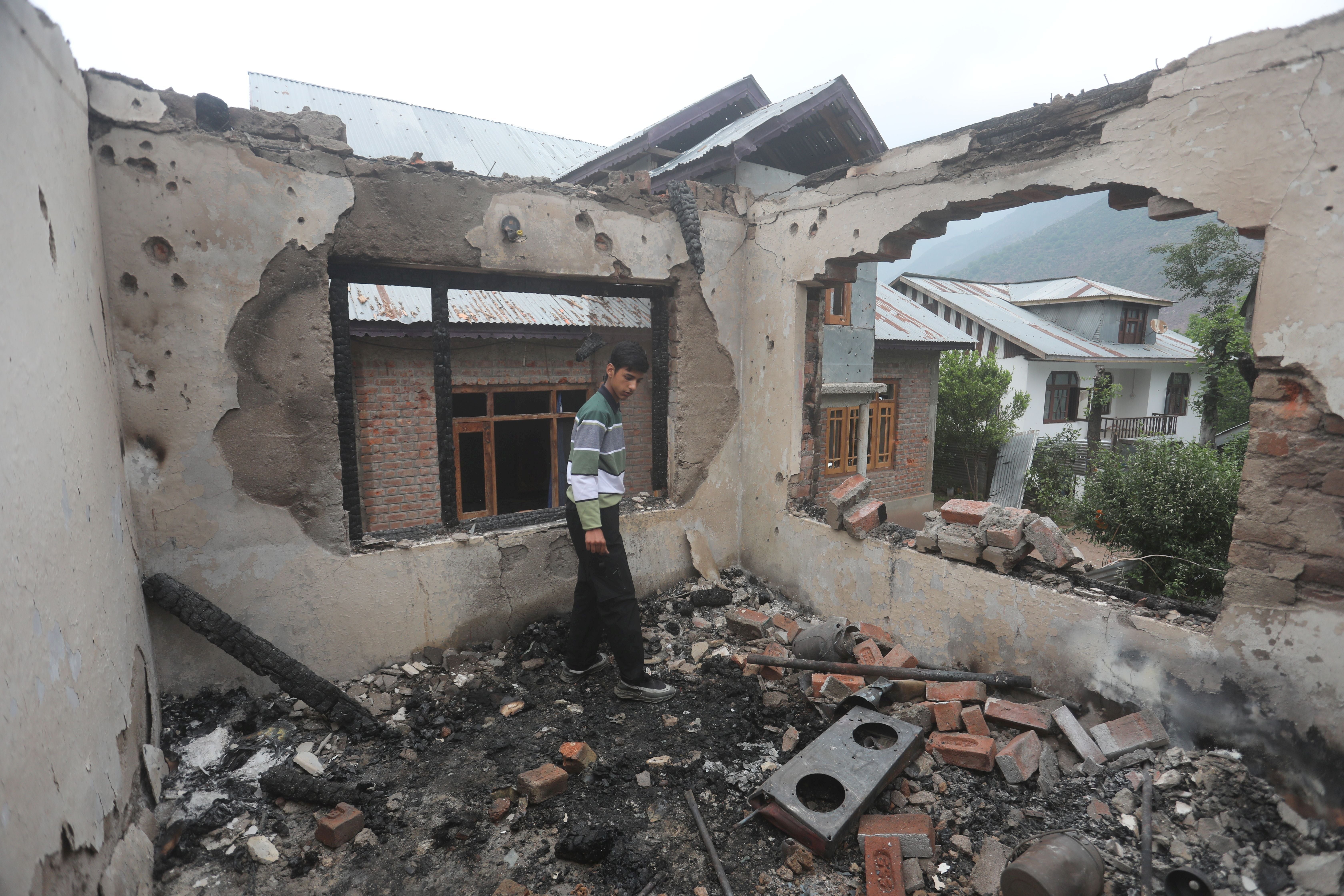 A Kashmiri boy inspects a house damaged after cross-border shelling from Pakistan, at Salamabad village in Uri, north of Srinagar, the summer capital of Indian Kashmir