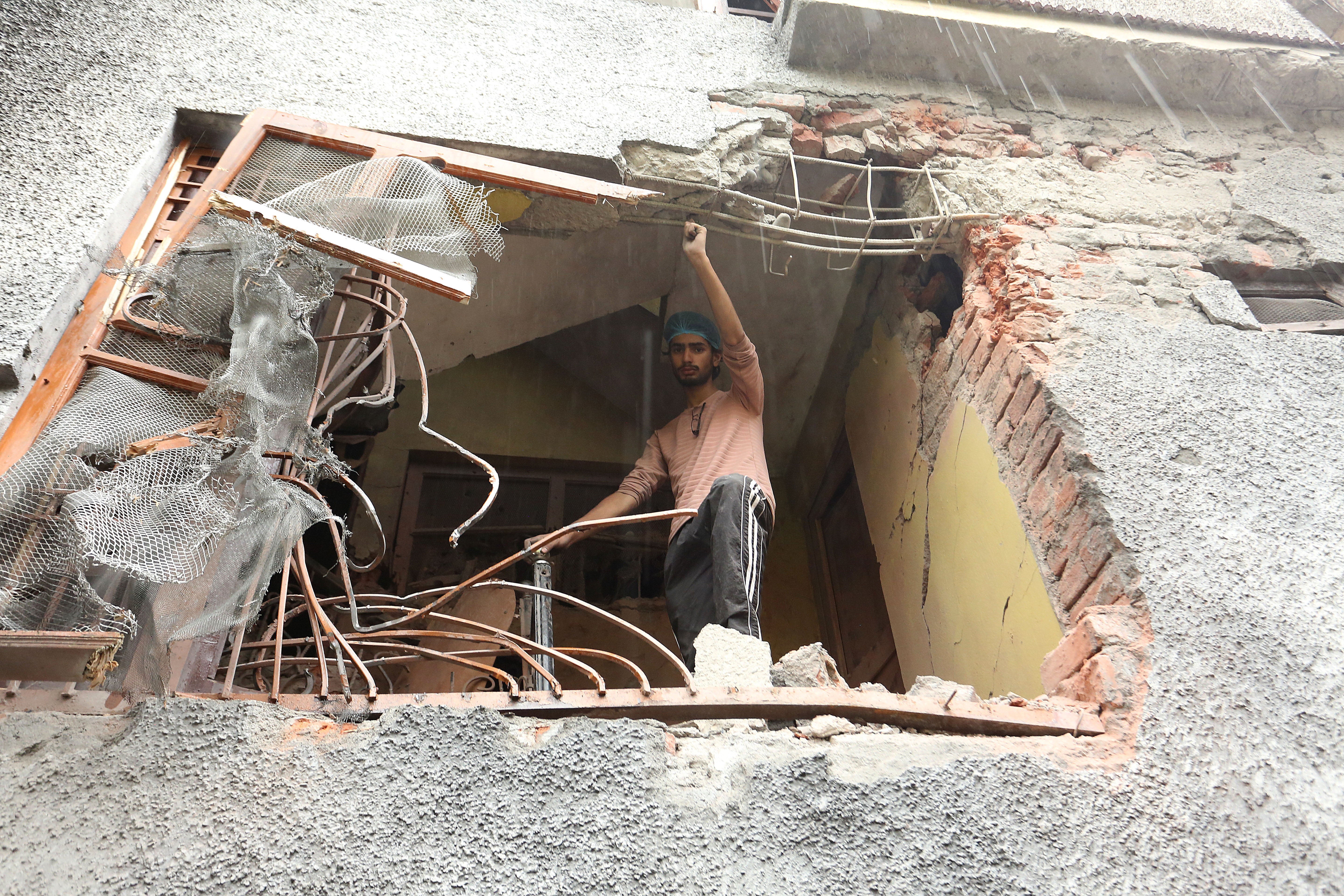 A man stands in a damaged house in Poonch district, India-administered Kashmir