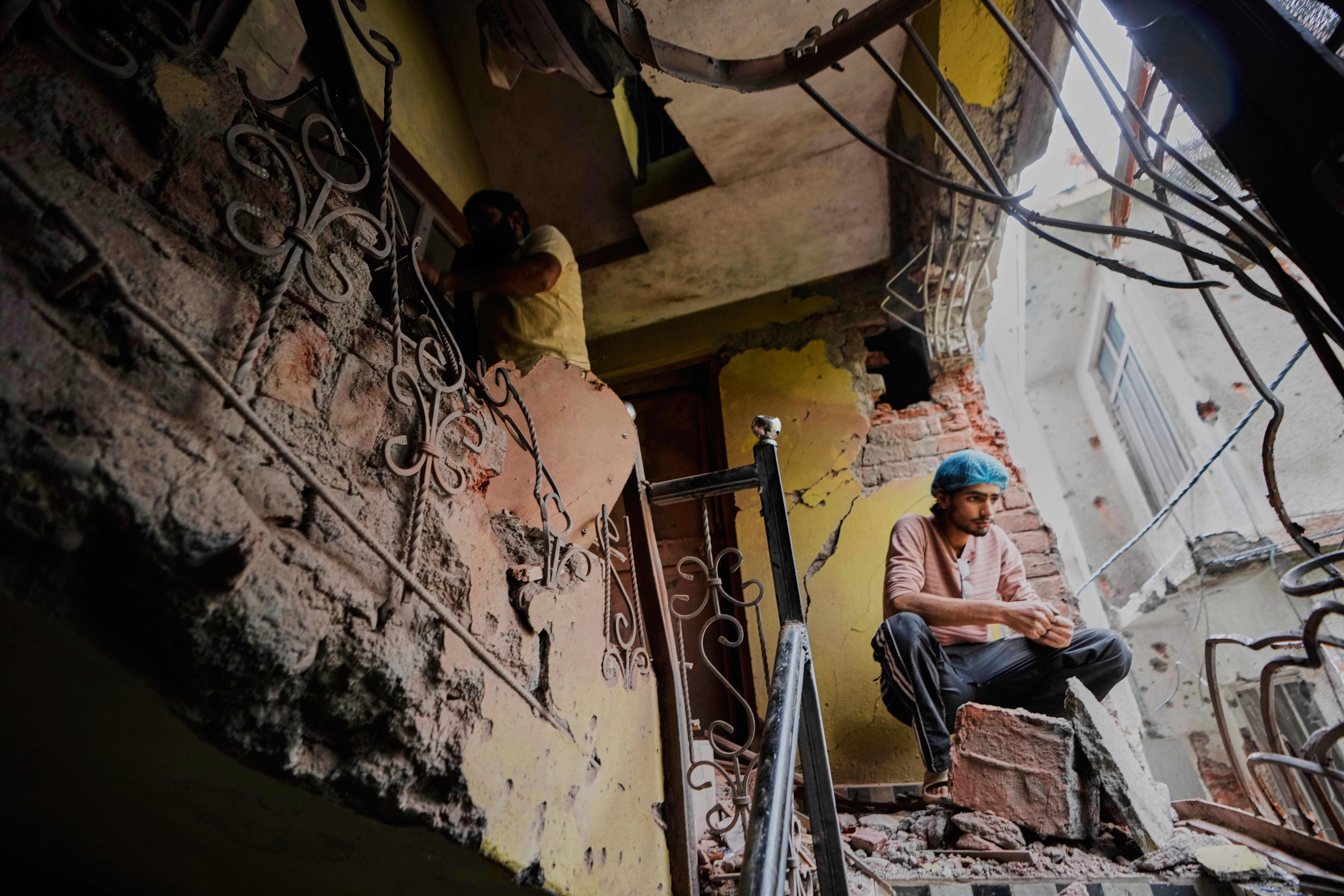 A man sits in his house damaged by Pakistani artillery shelling in Poonch, along the Line of Control in Indian-controlled Kashmir