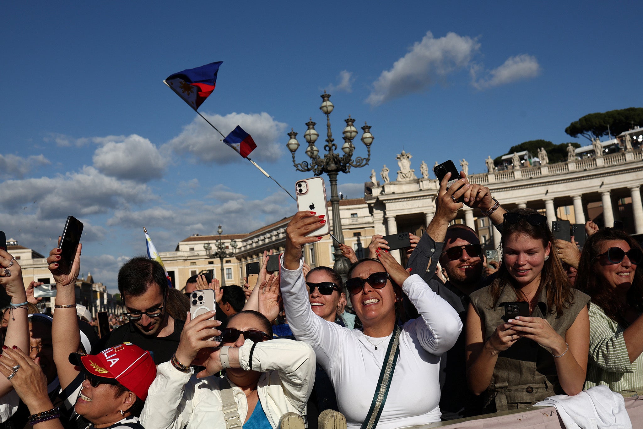 People in St Peter’s Square react to the white smoke rising from the Sistine Chapel