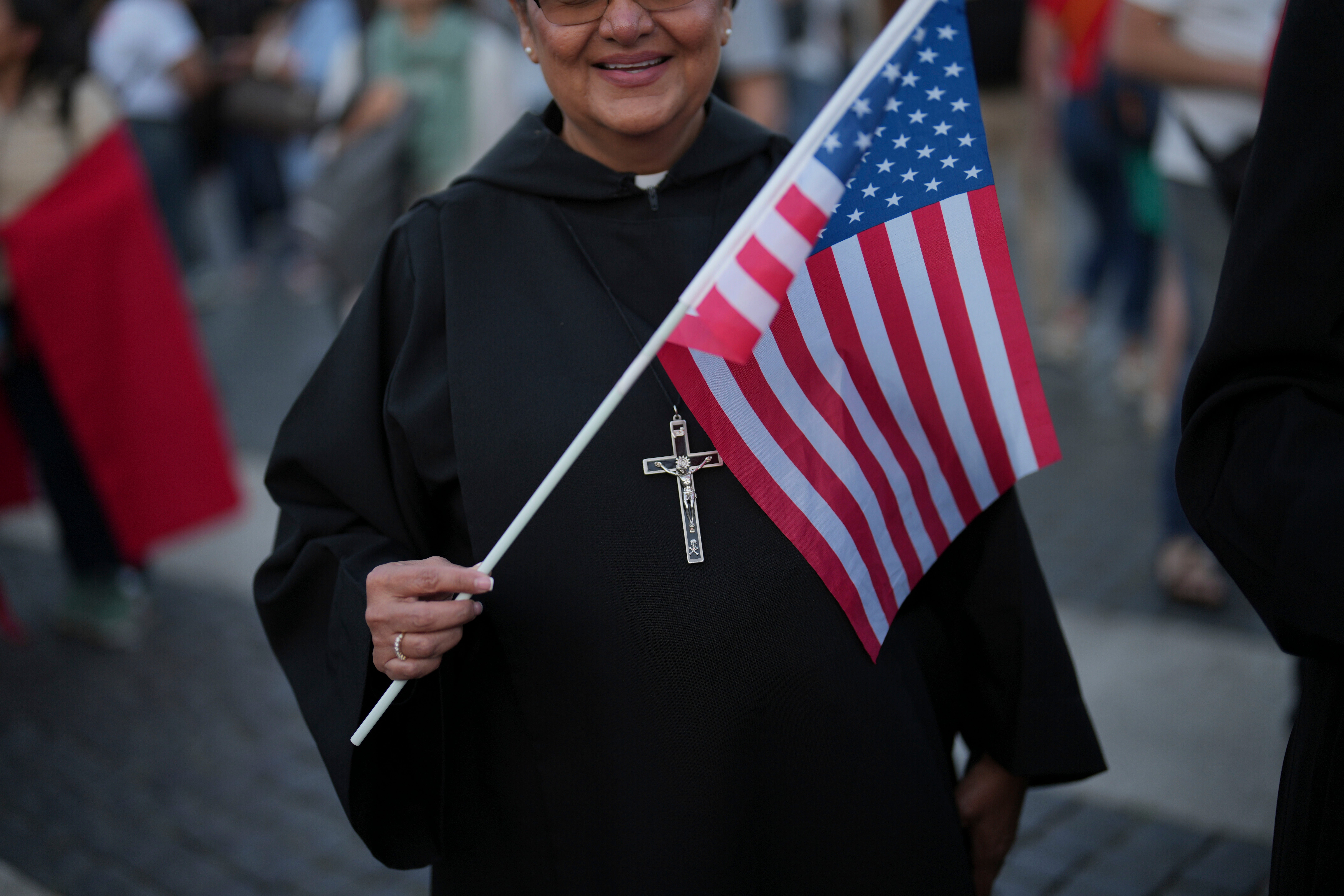 A nun holds a US flag during the speech of the newly elected Pope Leo XIV