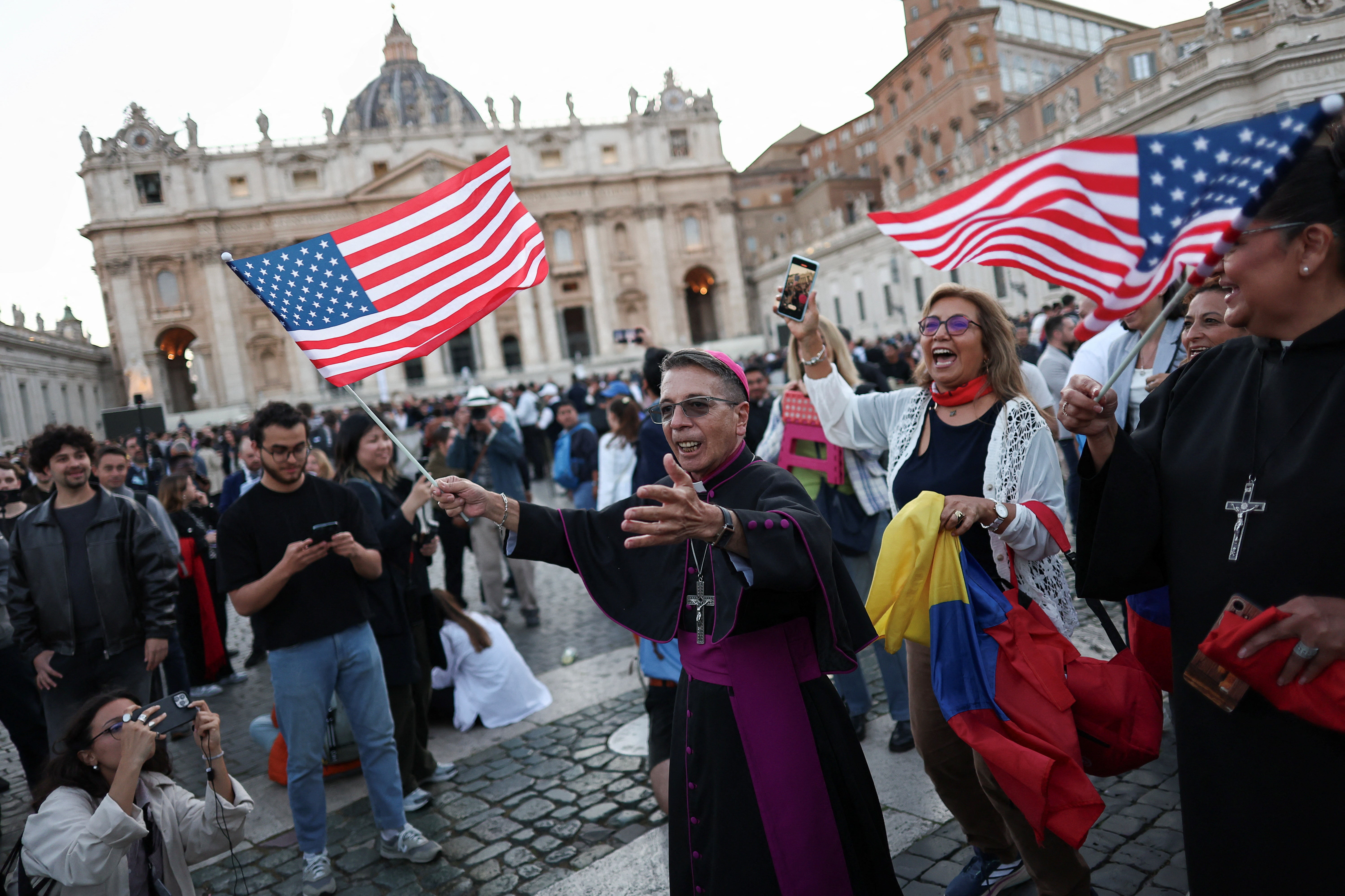 Onlookers wave American flags following the announcement that Chicago-born Prevost had been elected as the new pope