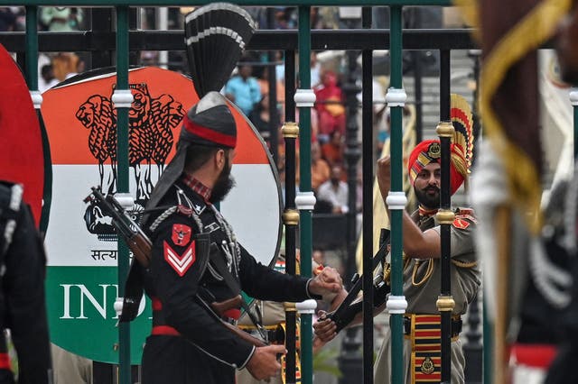 <p>A Pakistani Ranger (L) and an Indian Border Security Force (BSF) personnel perform during the 'Beating Retreat' ceremony at the border gates of Pakistan and India, at the Wagah border post near Lahore</p>