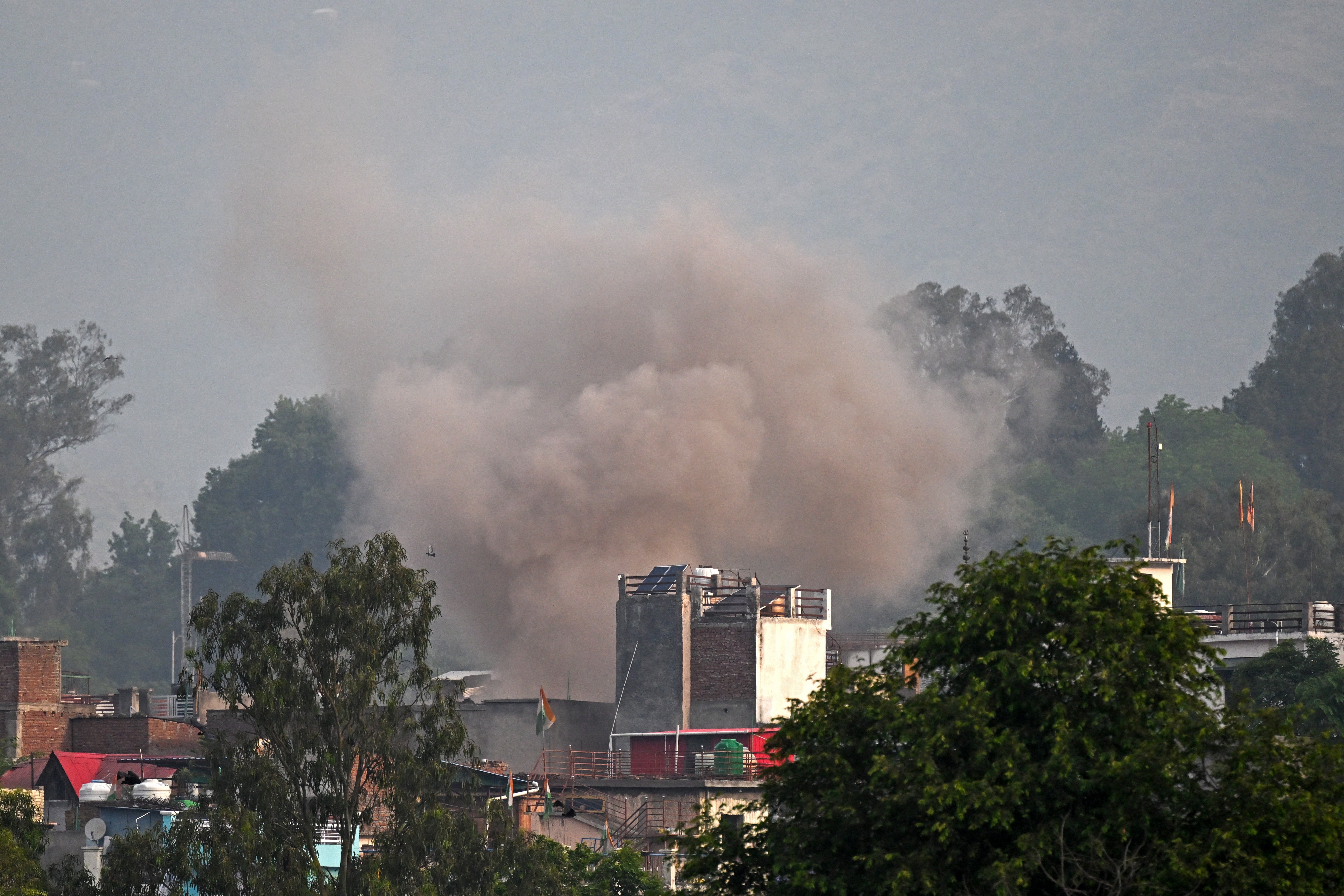 Smoke billows after an artillery shell landed in the main town of Poonch district