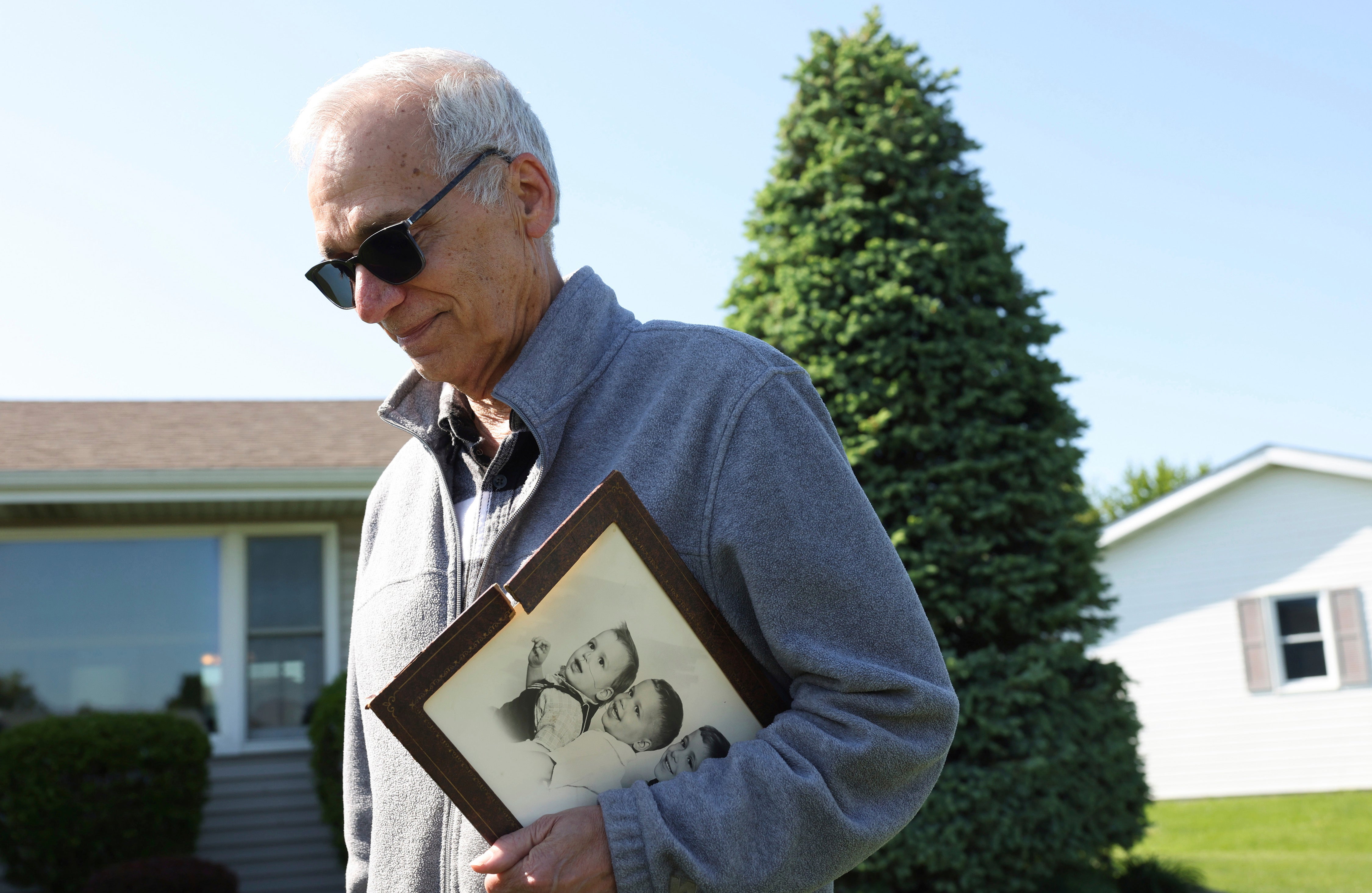 John Prevost, the brother of Pope Leo XIV, holds a portrait of the three Prevost brothers from 1958 while answering reporters' questions outside his home Thursday, May 8, 2025, in New Lenox, Illinois.