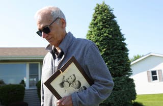 John Prevost, the brother of Pope Leo XIV, holds a portrait of the three Prevost brothers from 1958 while answering reporters' questions outside his home Thursday, May 8, 2025, in New Lenox, Illinois.