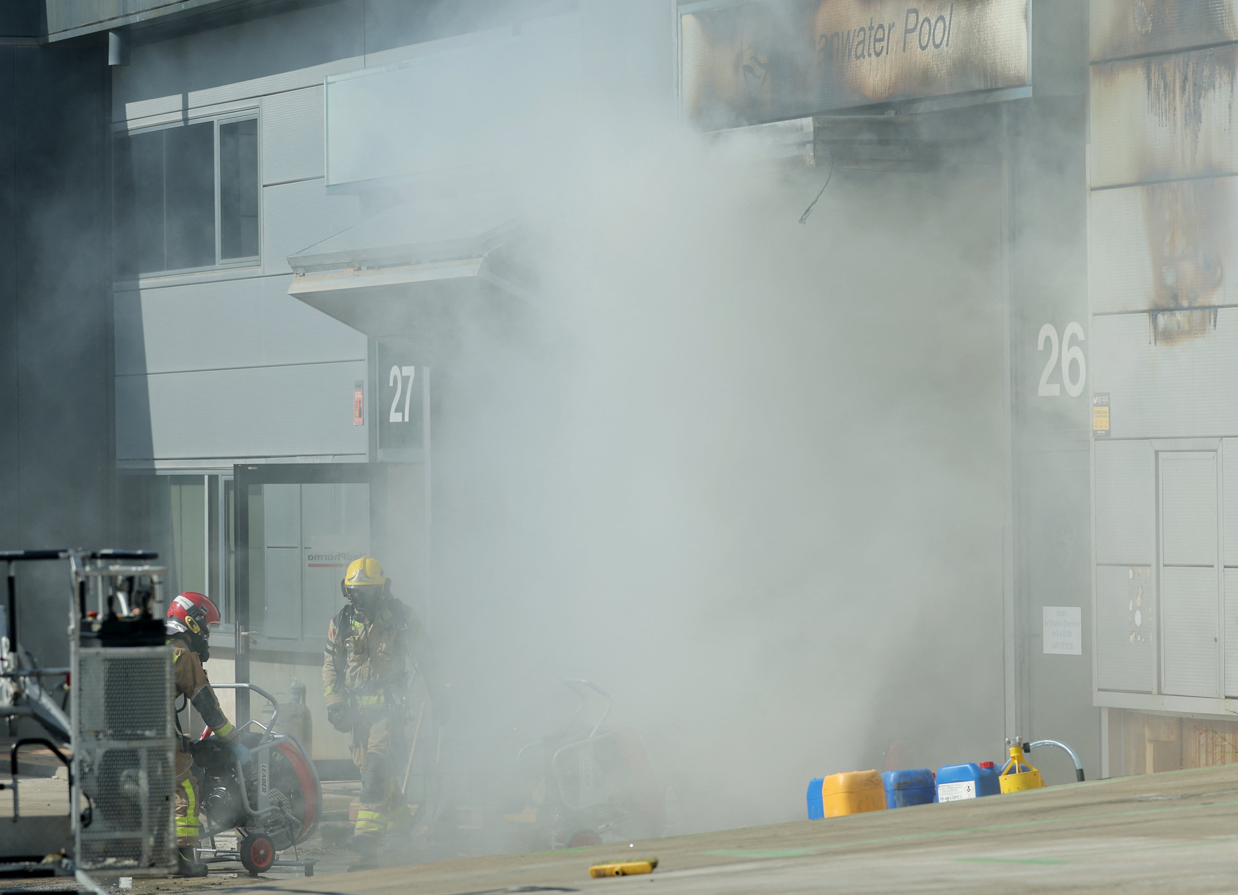 Firefighters work on a site of a burnt building storing pool cleaning products, in the coastal city of Vilanova i la Geltru, south of Barcelona on May 10, 2025