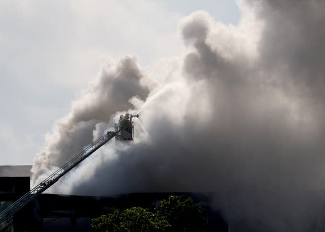 <p>Emergency staff's members on a platform are seen as smoke billows from a building storing pool cleaning products, in the coastal city of Vilanova i la Geltru, south of Barcelona on May 10, 2025</p>
