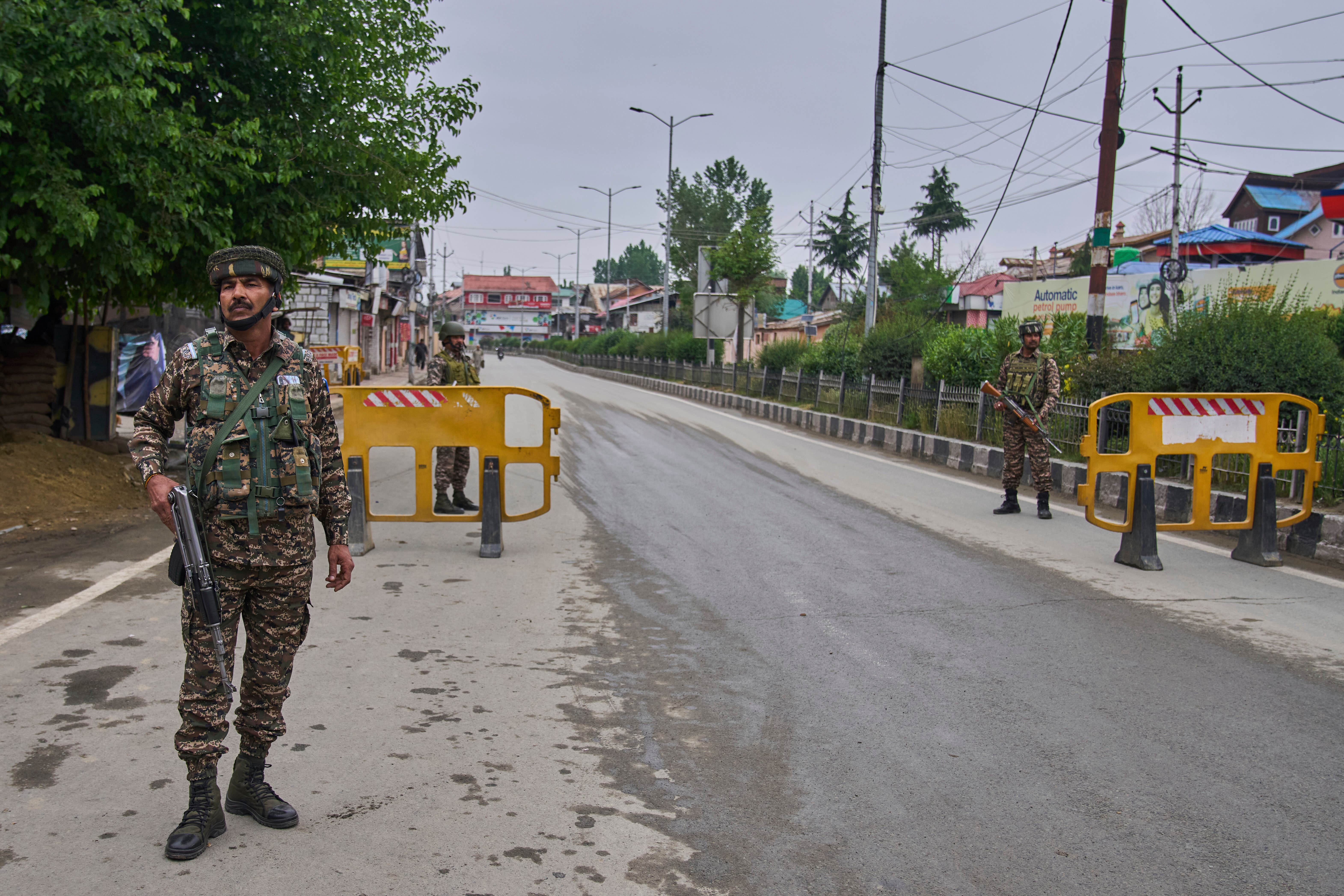 Indian paramilitary soldiers guard a temporary checkpoint on a road leading to the airport after loud explosions were heard in Srinagar, in Indian-controlled Kashmir (Dar Yasin/AP)