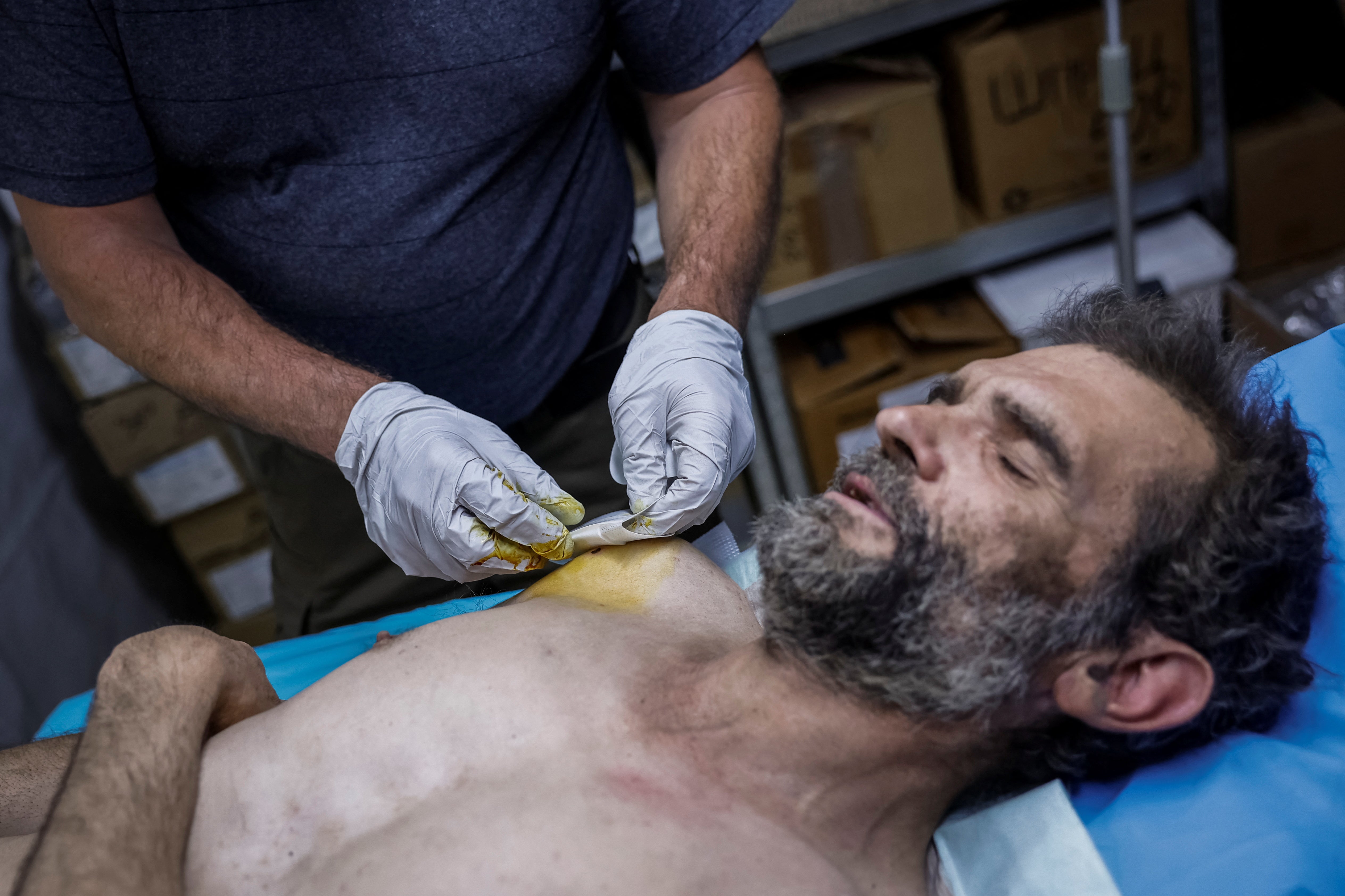 Oleh, 51-years-old, medic of the 128th Separate Mountain Assault Transcarpathian Brigade of the Armed Forces of Ukraine, helps a wounded Ukrainian serviceman at the unitâs medical stabilisation point, amid Russia's attack on Ukraine, in Zaporizhzhia region, Ukraine May 9, 2025. REUTERS/Alina Smutko