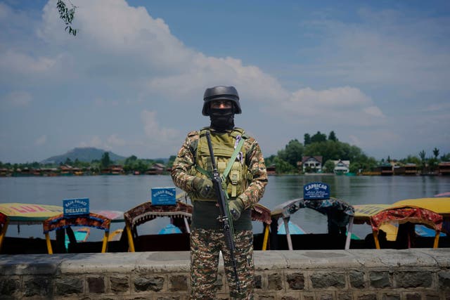 <p>An Indian paramilitary soldier stands guard on the banks of Dal Lake (AP Photo/Mukhtar Khan)</p>