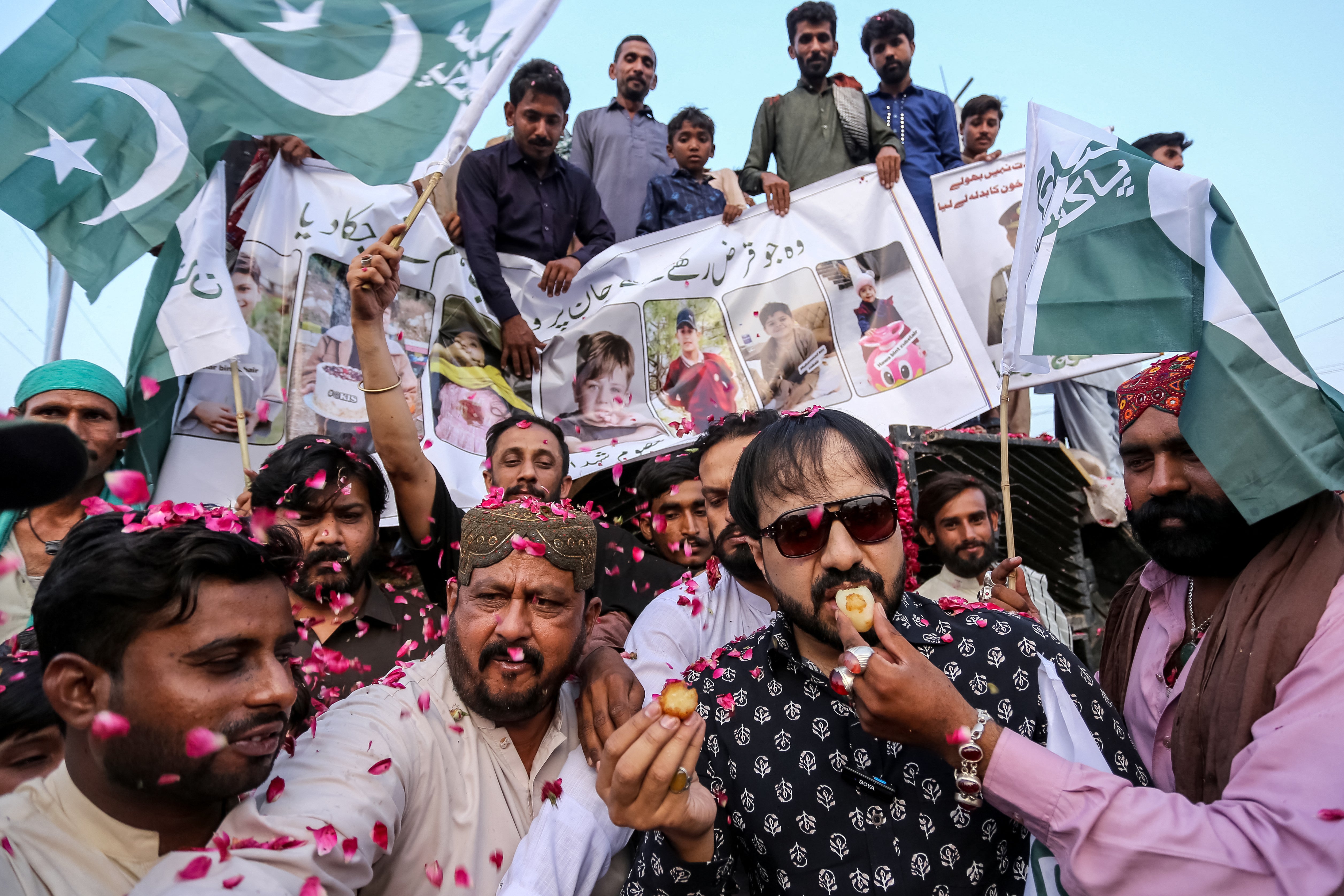 Pakistani people exchange sweets as they celebrate after the ceasefire between Pakistan and India, in Multan on May 10, 2025.