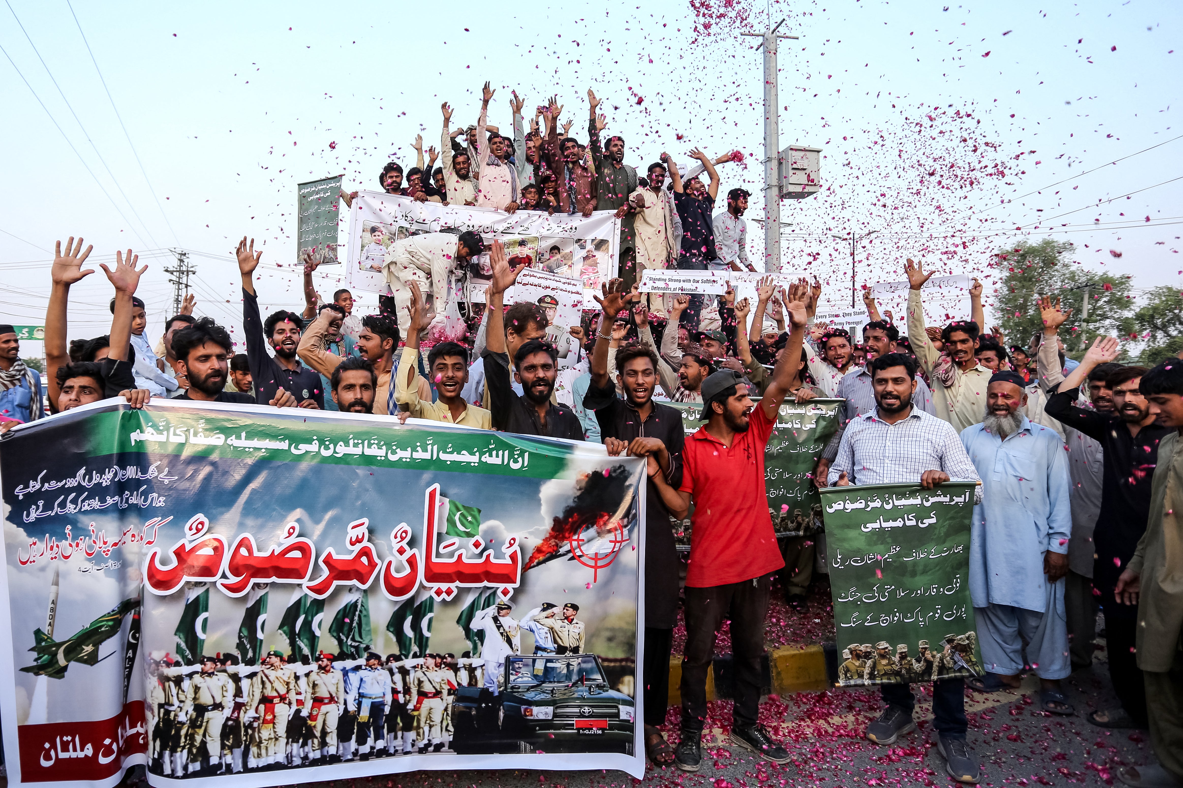 Pakistani people shower rose petals as they celebrate after the ceasefire between Pakistan and India, in Multan on May 10, 2025.