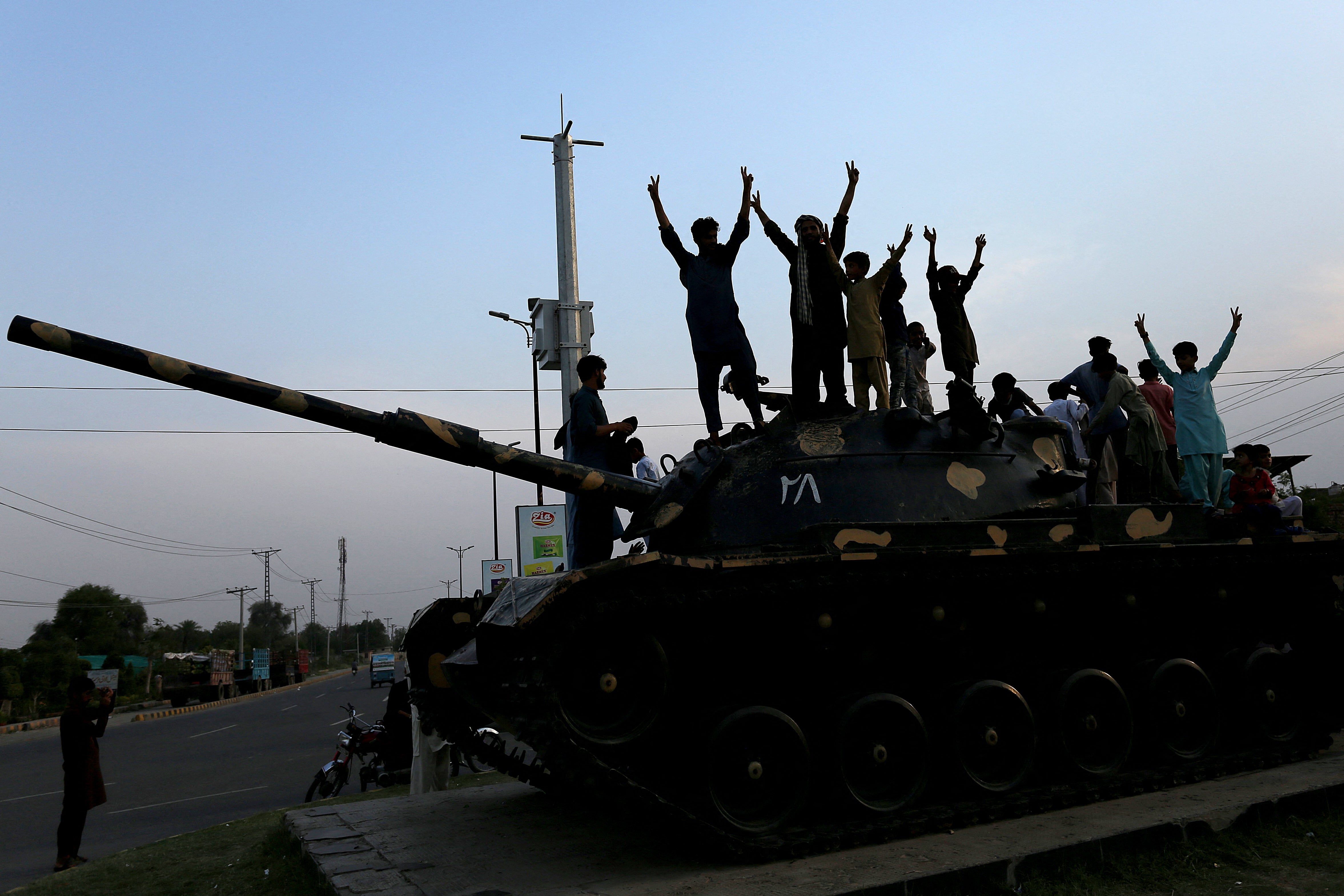 Pakistani people flash victory signs as they celebrate after the ceasefire between Pakistan and India, in Multan on 10 May 2025