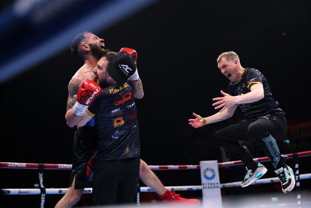 <p>Cacace celebrates with his team after retaining the IBO super-featherweight strap</p>