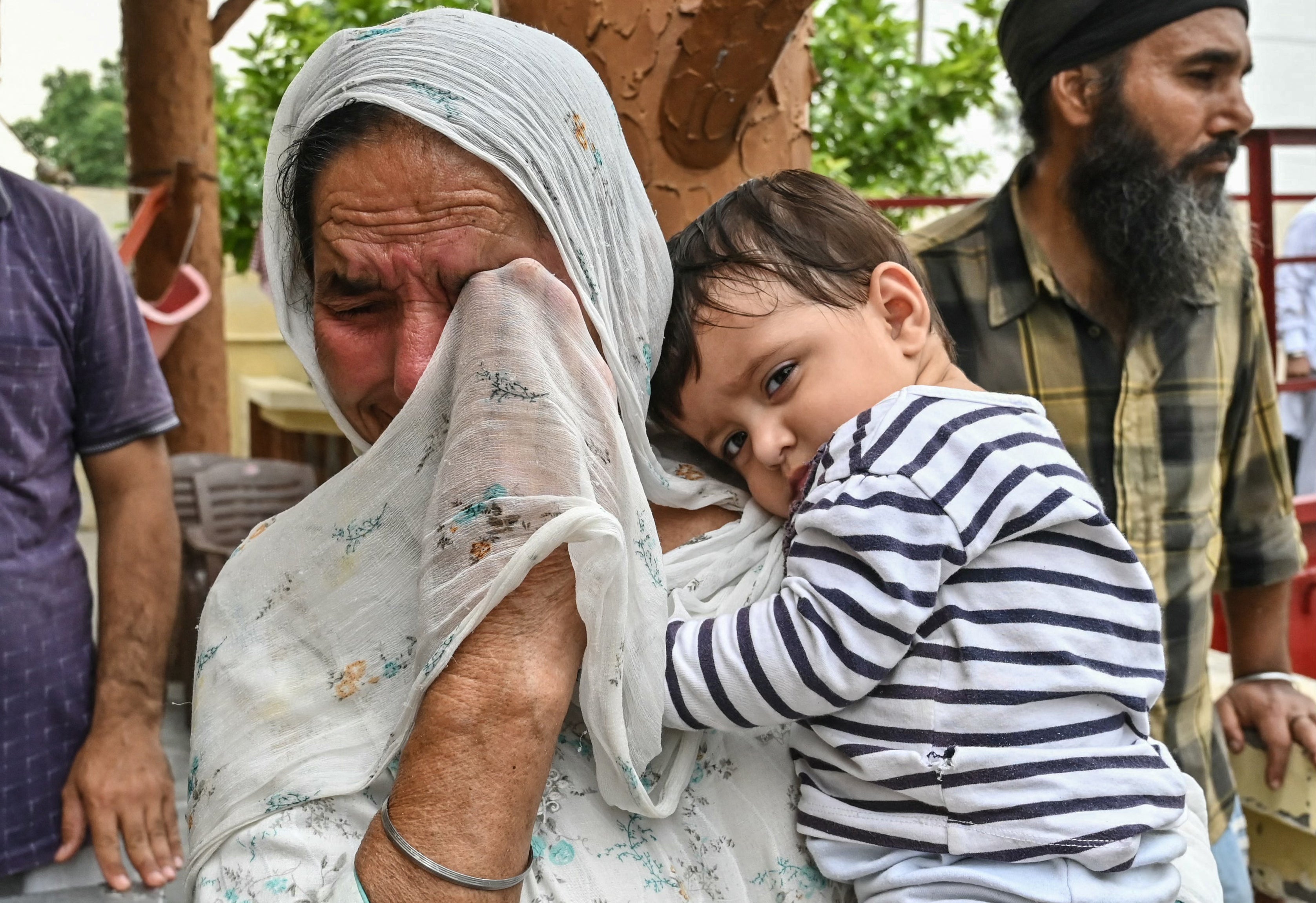 The woman wearing a child breaks as they evacuate the next increase in border tensions, in Havelian village near India-Pakistan border mail in Amritsar