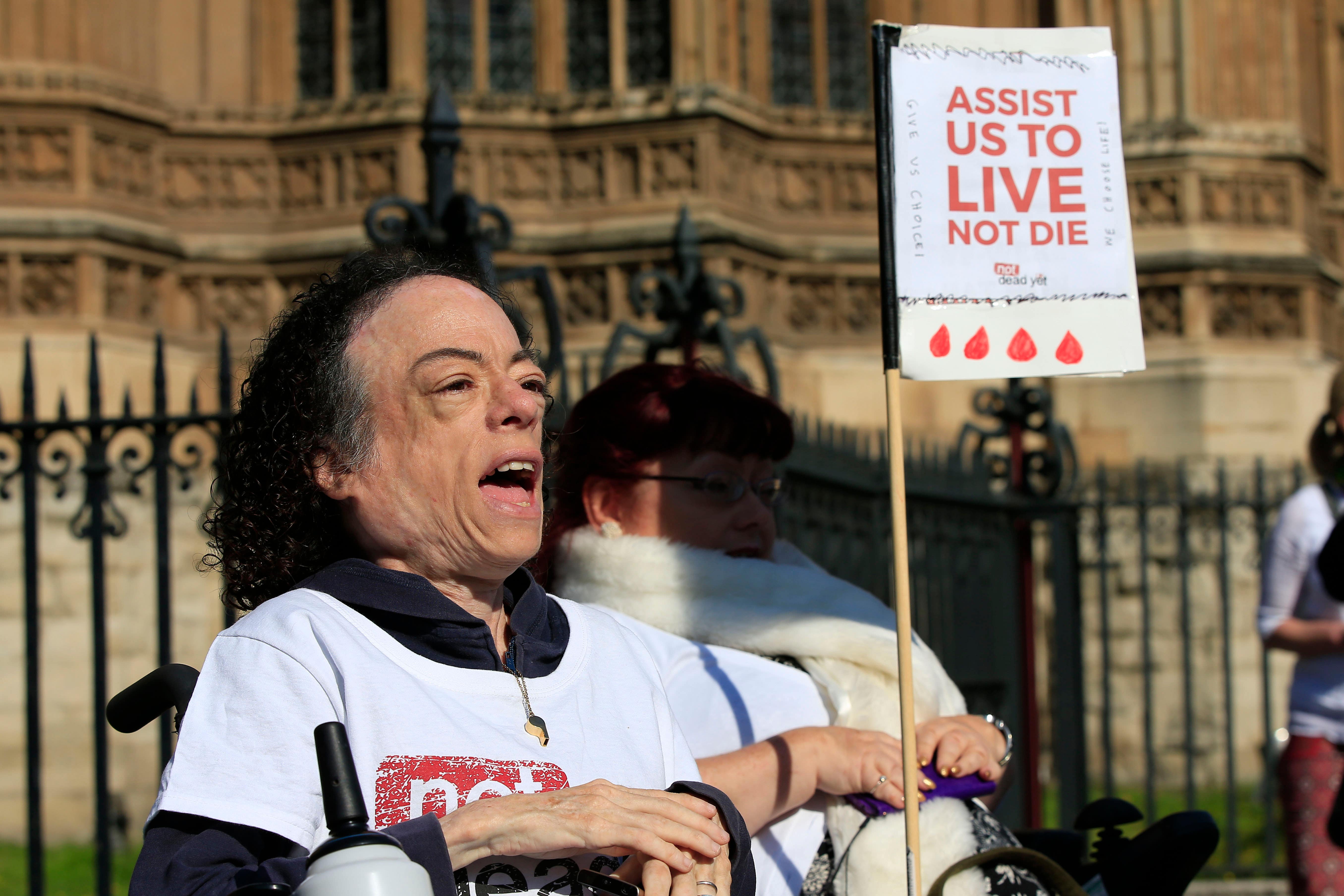 Actress Liz Carr holding a sign saying assist us to live not die’ (Jonathan Brady/PA)
