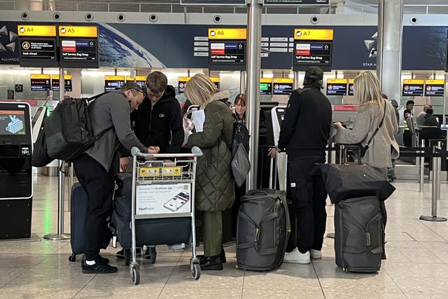 <p>Passengers queue at a check-in desk at Heathrow’s terminal 2</p>