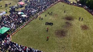 Moment bullfight spectators run for safety after bull escapes ring