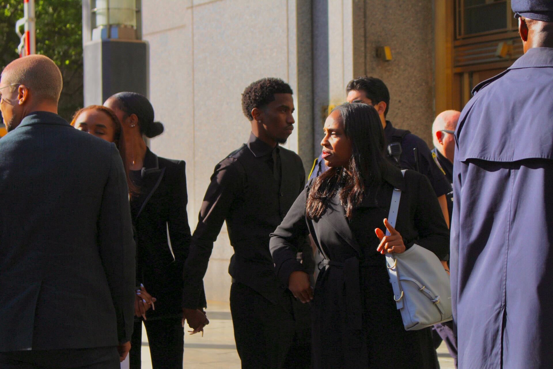 Christian Combs enters the courthouse holding hands with his siblings.