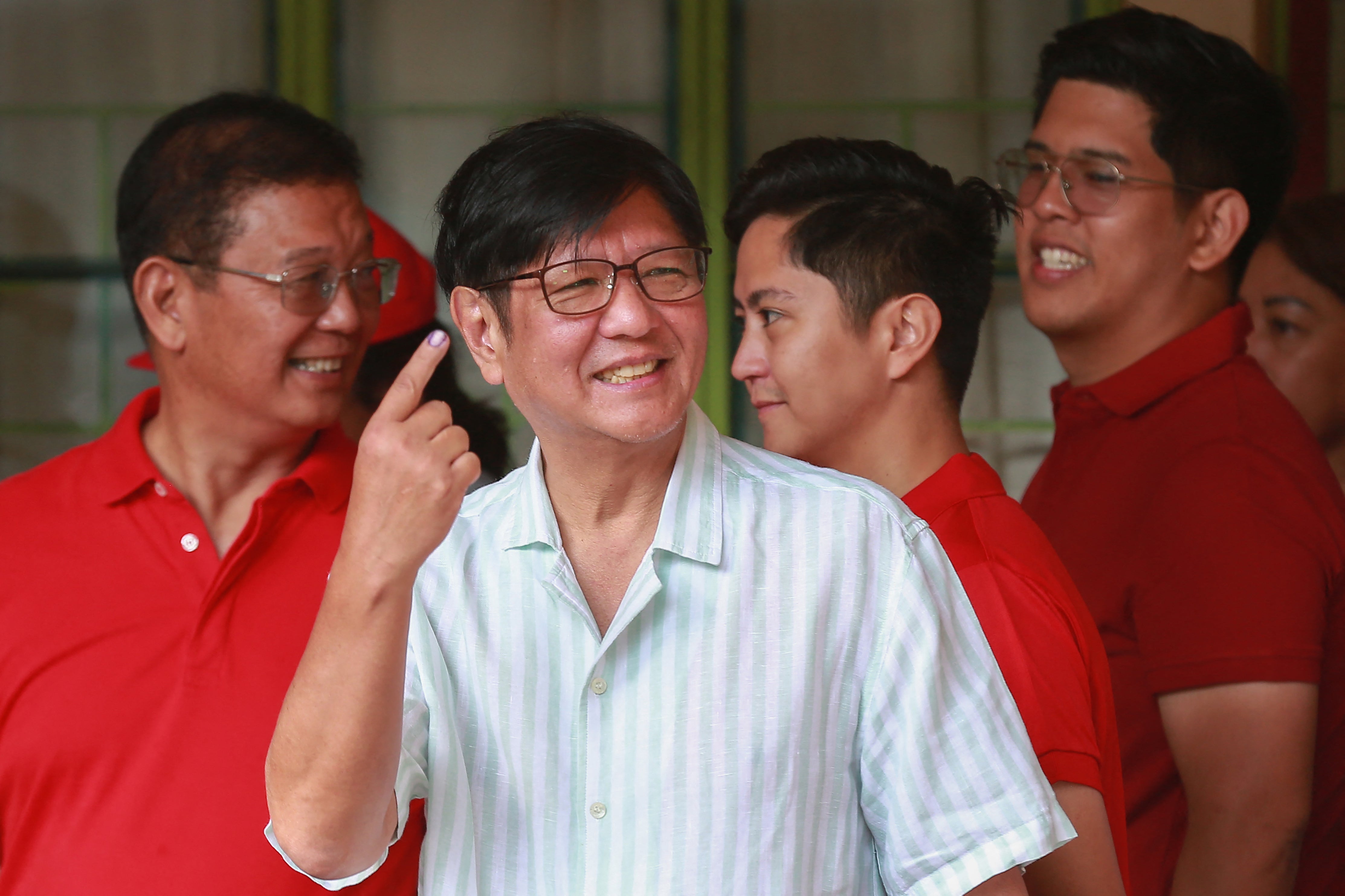 Philippine President Ferdinand Marcos shows his inked finger after voting in the mid-term election at a polling station in Batac town, Ilocos Norte province
